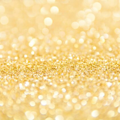 Abstract gold glitter background with a bokeh effect, ideal for festive designs.