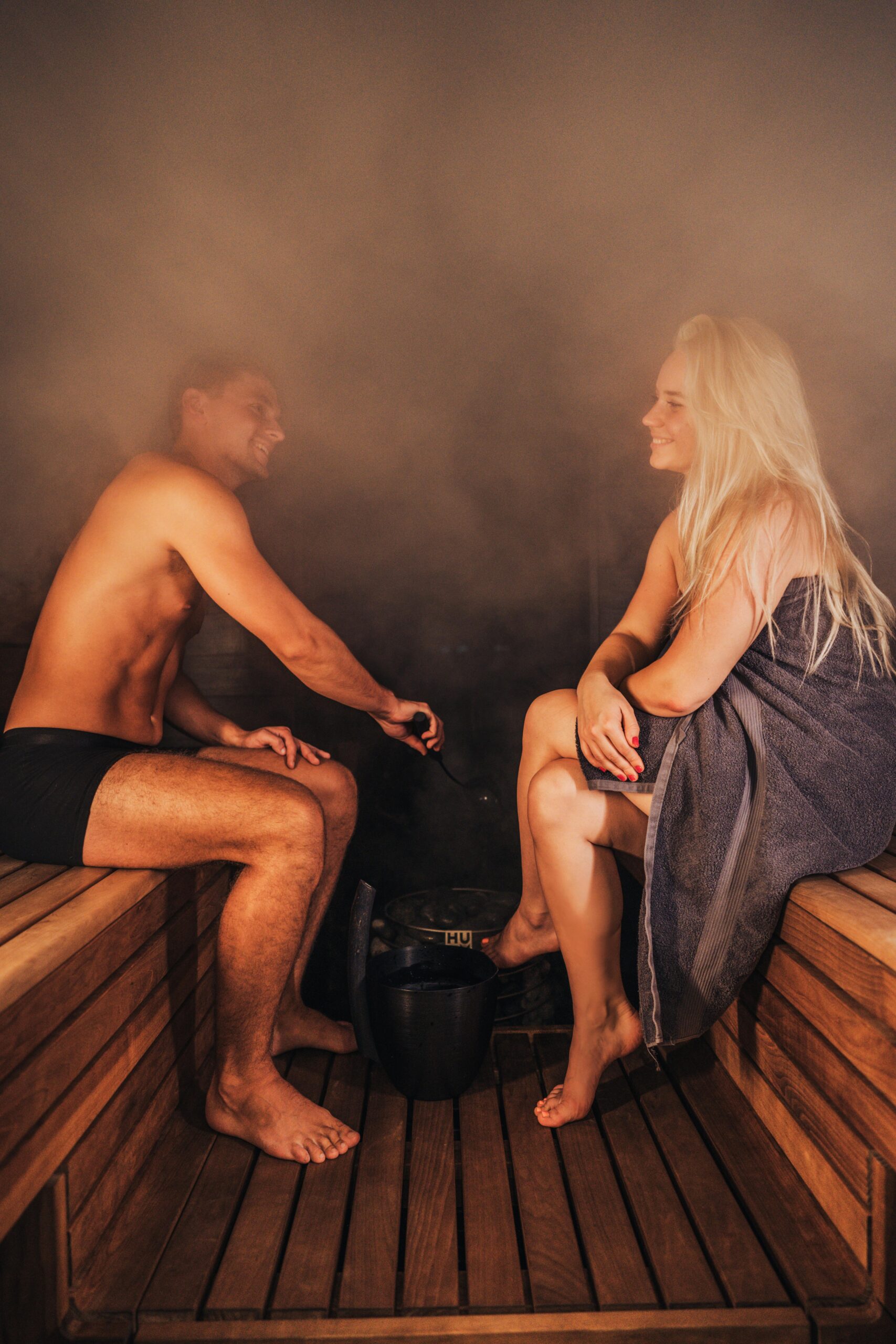 A relaxing sauna experience with two adults enjoying steam and warmth, embodying wellness and relaxation.